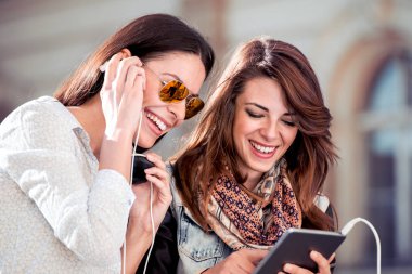 Tablet kullanma ve tablet, teknoloji kavramı üzerinden müzik dinleme genç arkadaşlar.