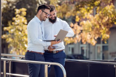 Bir dizüstü bilgisayar kullanarak çalışma proje hakkında açık, konuşurken iki iş adamları.