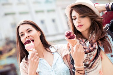 Atış iki genç arkadaşlar alışveriş sonra bir yaz gününde dondurma keyfi.