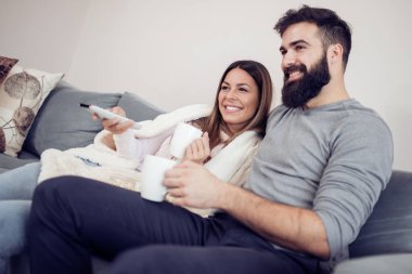 Onların evinde rahatlatıcı, kanepede oturan, bir film seyrederken ve patlamış mısır yemek Genç Çift. 