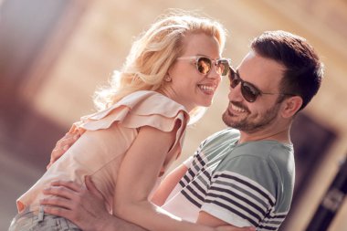 Mutlu genç çift dışarıda eğleniyor ve gülümsüyor..