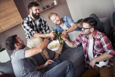 Genç erkek içki şişeleri ile dinlenme, futbol hakkında konuşuyor ve gülümseyen.