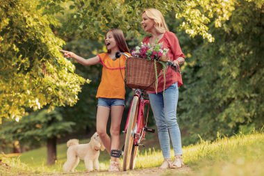 Anne ve kızı birlikte eğleniyor, Bisiklete binmek.