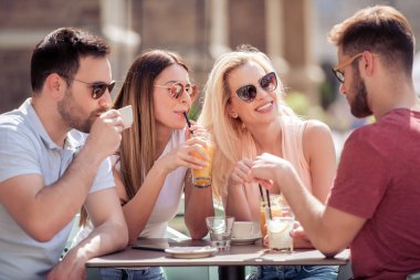 Toplantı ve kafede kahve içme mutlu genç arkadaşlar. İnsanlar, eğlence, mutluluk ve yaşam tarzı kavramı.