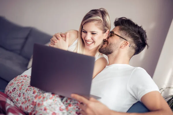 愉快的夫妇一起放松在沙发和使用膝上型电脑在家庭在客厅里 — 图库照片