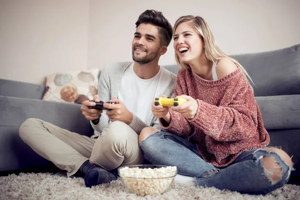 彼らのリビングルームでビデオゲームをプレイする遊び心のある若いカップル — ストック写真