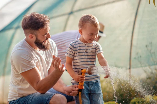 Junger Vater Mit Seinem Sohn Bei Der Gartenarbeit — Stockfoto