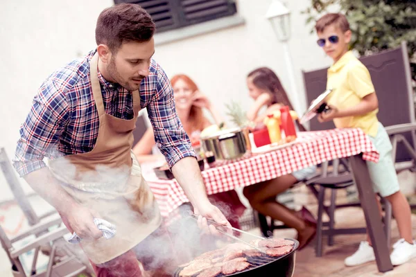 レジャー 休日コンセプト 夏屋外パーティーで彼の家族のバーベキュー グリルで肉を料理人 — ストック写真