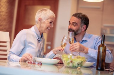 Evde birlikte yemeğe mutlu olgun çift.