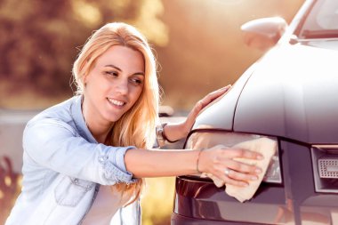 Kadın modern araba temizlik mikrofiber bezle.