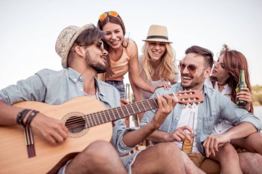 Sahilde eğleniyor ve soğuk bir bira içme arkadaş.