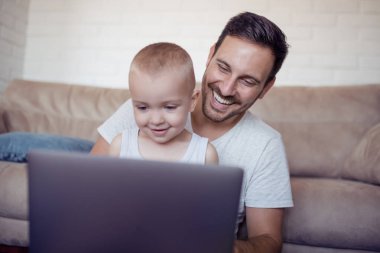 Aile, babalık, teknoloji ve insan kavramı - mutlu baba ve küçük oğlu ile dizüstü izle çizgi film.