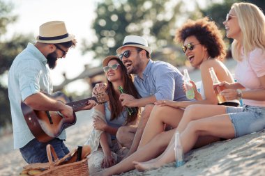 Hafta sonu zevk ve having fun sahilde gitar ile neşeli arkadaşları.