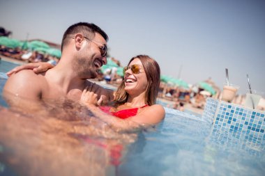 Mutlu genç çift rahatlatıcı ve huging yüzme havuzunda.
