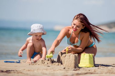 Anne ve oğlu kum plaj eğleniyor.