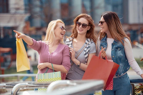 Happy friends shopping. Three beautiful young women enjoying shopping in the city.