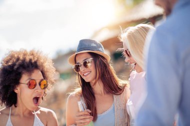 Mutlu genç arkadaş sahilde parti grubu.