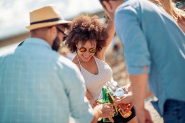 Mutlu genç arkadaş sahilde parti grubu.