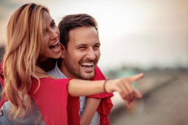 Mutlu genç çift dışarıda eğleniyor ve gülümsüyor..