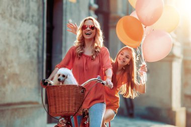 Anne ve kızı birlikte eğleniyor, Bisiklete binmek.