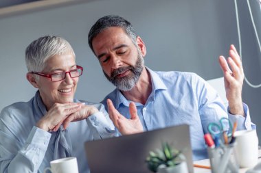 Olgun işadamı belgeleri ofisinde kadın meslektaşım için gösterilen.