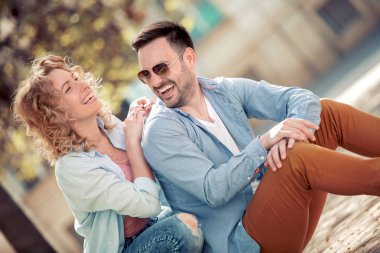 Konuşmak ve açık havada birlikte oturan gülümseyen güzel çift.