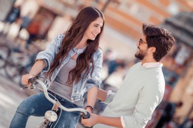 Şirin çift bisikletle güneşli bir günde şehirde binmek..