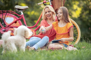 Güzel anne ve kızı parkta piknik. Eğlenceli ve Aile kavramı.