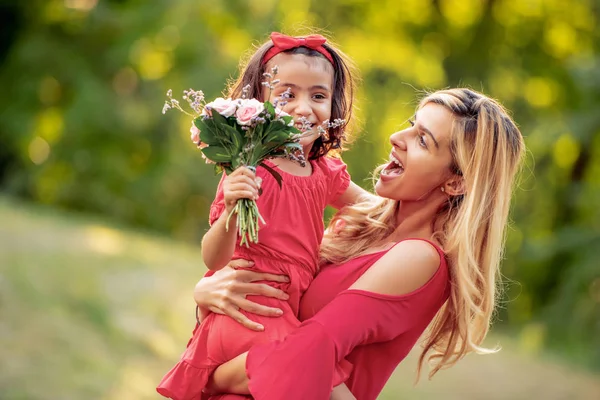 Mother\'s day.Cute cheerful daughter with mother play outdoors in park.