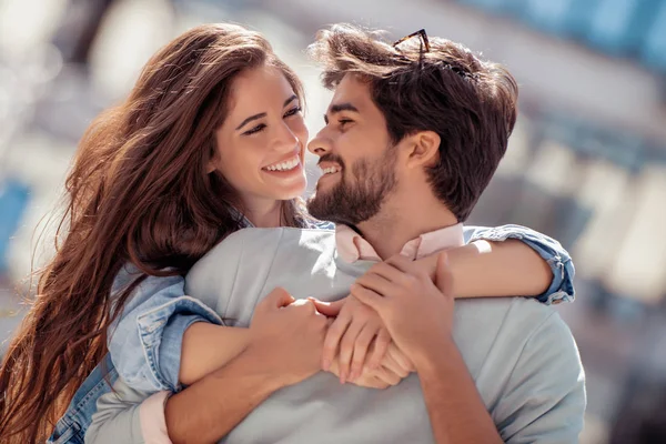 Mutlu genç çift dışarıda eğleniyor ve gülümsüyor..