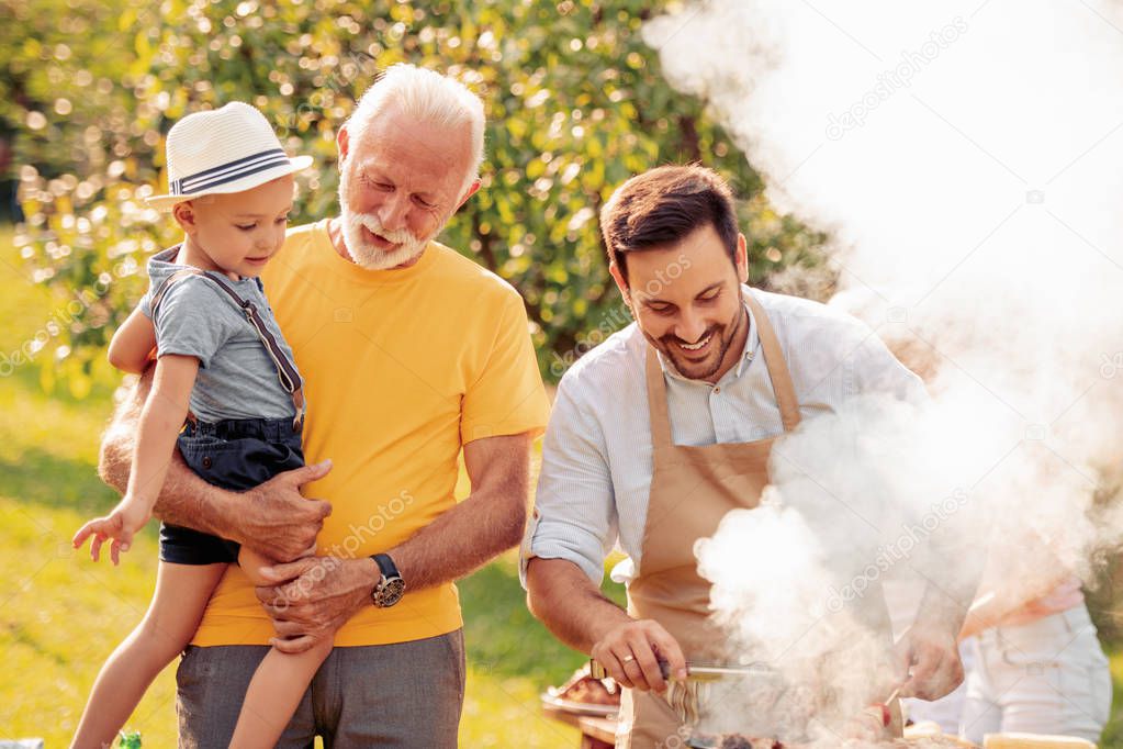 Family having a barbecue party in their garden in summer.