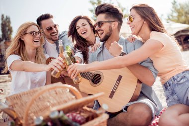 Gençlerin grup Sahilde piknik mutlu. Yaz, tatil, tatil, müzik ve insan kavramı.