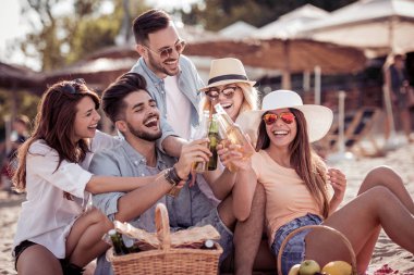 Gençler eğleniyor piknik sırasında sahilde.