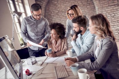 Modern ofiste iş projesinde çalışan bir grup iş adamı.