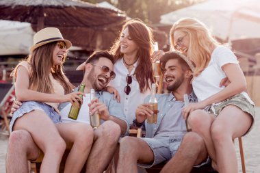 Bira içip beach partide eğleniyor arkadaşlar. Yaz, tatil, tatil, mutluluk ve insanlar kavramı.