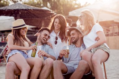 Bira içip beach partide eğleniyor arkadaşlar. Yaz, tatil, tatil, mutluluk ve insanlar kavramı.