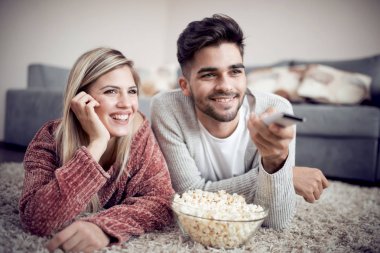 Tv izlerken evde, yerde yatarken mutlu genç çift.