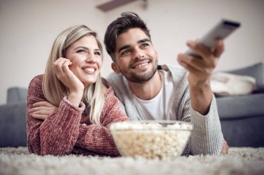 TV izlerken, evde patlamış mısır yemek mutlu çift.