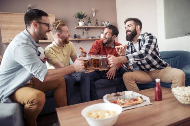 Grup dört erkek arkadaşıyla bira içme ve pizza yemek televizyonda futbol maçı izlerken.
