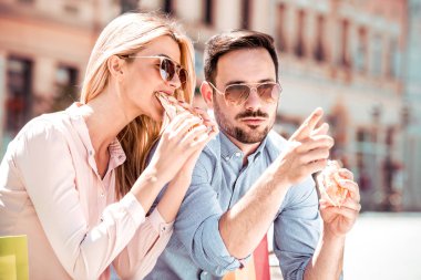 Mutlu genç çift. Onlar gülüyor ve sandviç yeme ve having a büyük zaman.