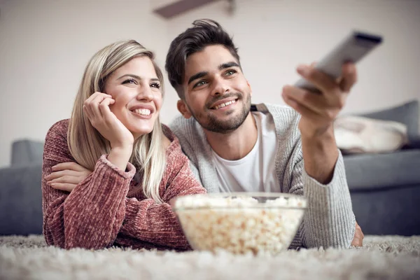 幸福的夫妇看电视和在家里吃爆米花 — 图库照片