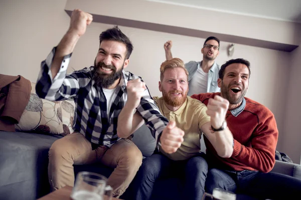 Futbol taraftarları duygusal olarak oturma odasında maç izliyor..