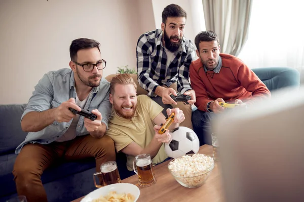 Video oyunları oynarken arkadaş grubu. Oturma odasında ve birlikte oynayan gençler.