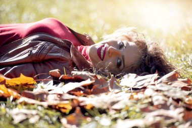 Mutlu kız portre gülümseyen, yaprakları sonbaharda yalan.