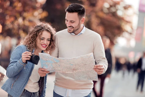 Couple of tourist traveling and using map.Couple of tourist exploring a city.