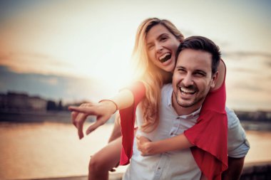 Mutlu genç çift dışarıda eğleniyor ve gülümsüyor..