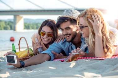 Yaz tatili, teknoloji ve plaj kavramı - selfie sahilde alarak arkadaşlar.