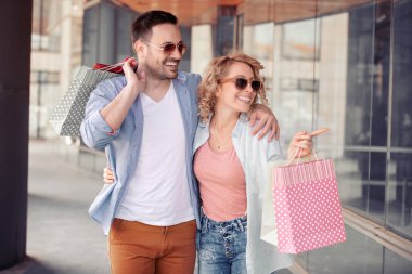 Alışveriş torbaları vitrin City bakarak ile satış, tüketim ve insanlar kavramı mutlu çift.