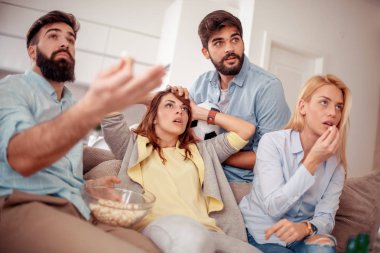 Neşeli grup arkadaşıyla evde maç izlerken.