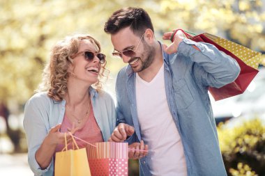 Mutlu genç çift alışveriş ve eğleniyor sonra parkta yürüyüş. Tüketim, insan, sevgi, dating ve yaşam tarzı kavramı
